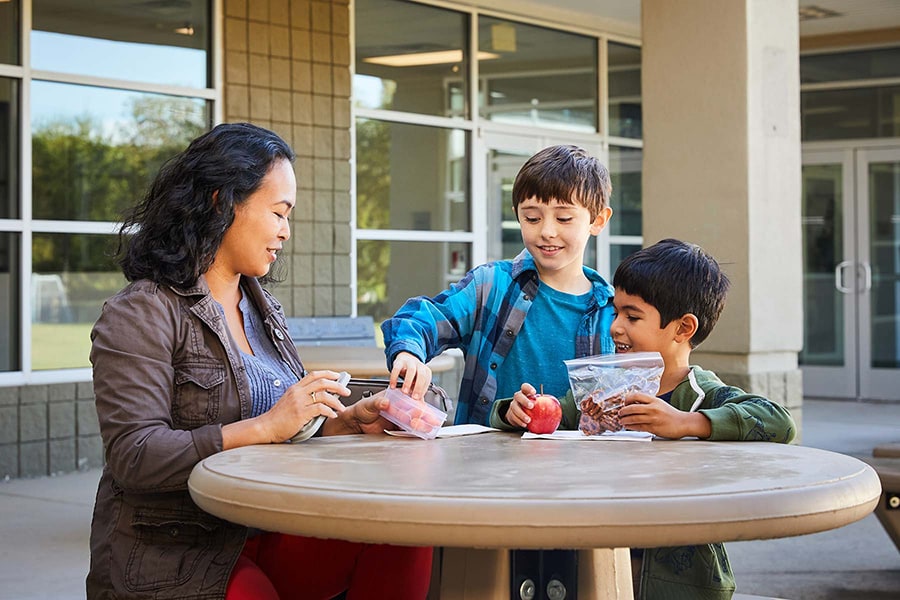 Mom offering protein-packed backpack snacks to kids