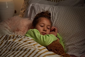 Young child soundly sleeping in bed